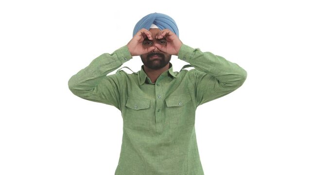 Young beard Indian man looking around throw imaginary binoculars, seeking something in distance. Isolated on white background.