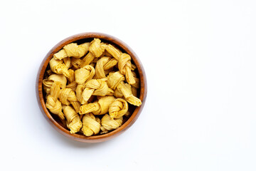 Dried bean curd knot in wooden bowl on white background.
