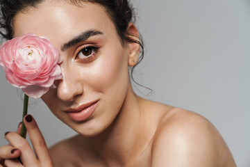 Naklejka premium Image of smiling half-naked woman posing with pink flower on camera
