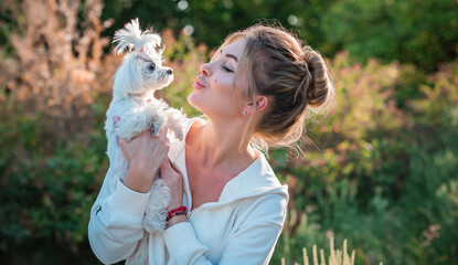 Obraz premium Woman with a Little fashionable luxury lapdog dog at walk, pet lifestyle