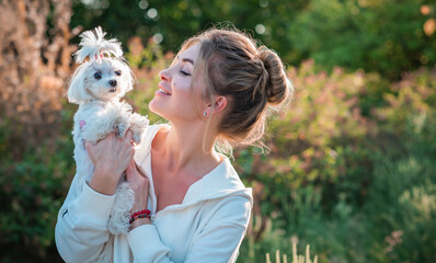 Obraz premium Woman with a Little fashionable luxury lapdog dog at walk, pet lifestyle