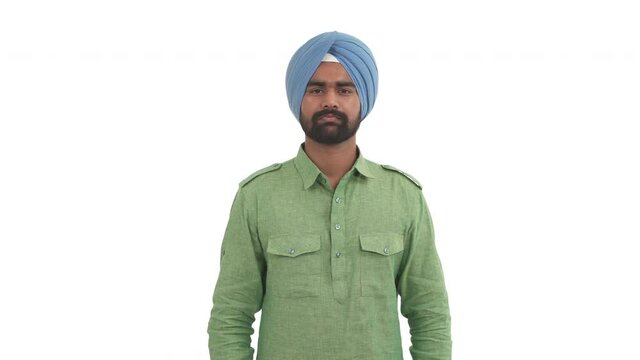 Portrait of doubting Indian man showing so-so gesture by waving both hands. Isolated on white background