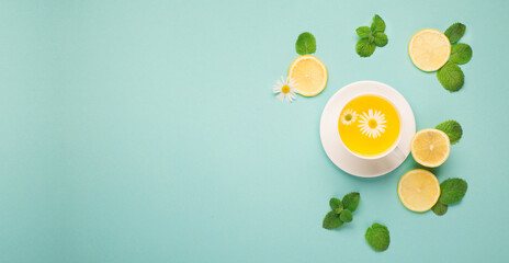 Herbal tea of chamomile flower with mint, ginger, lemon, honey on paper blue background.