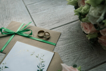 Bridal morning details composition. Top view of wedding rings, beautiful bouquet of pink flowers with ribbons. Flat lay.