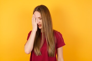 Beautiful Young beautiful caucasian girl wearing red t-shirt over isolated yellow background Yawning tired covering half face, eye and mouth with hand. Face hurts in pain.