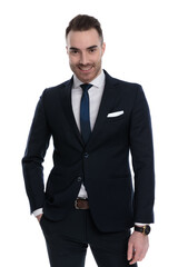 Confident businessman smiling with hand in pocket while standing