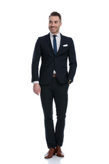 Charming businessman smiling and looking away with hand in pocket