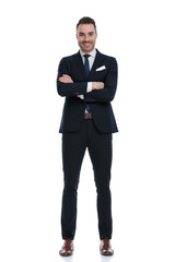 Happy businessman smiling with hands crossed while standing