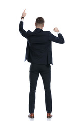 Back view of businessman pointing up and celebrating