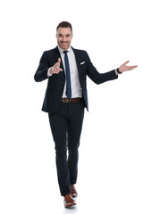 Smiling businessman pointing and presenting while walking
