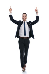 Cheerful businessman celebrating and pointing up with both hands