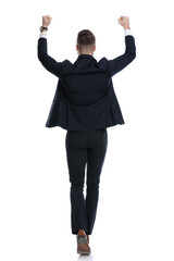 Rear view of happy businessman celebrating while walking