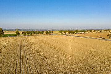 View from above on grain fields in warm evening light in Rheinhessen / Germany and a roundabout in the background