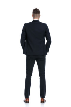 Back view of confident businessman holding hands in pockets
