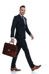 Side view of businessman holding briefcase and smiling