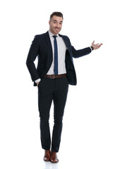 Happy businessman presenting with hand in pocket, smiling