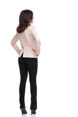 Back view of businesswoman standing with hands on hips