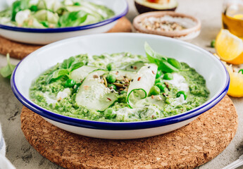 Cold green soup Gazpacho with cucumber, green peas, basil leaves and avocado.