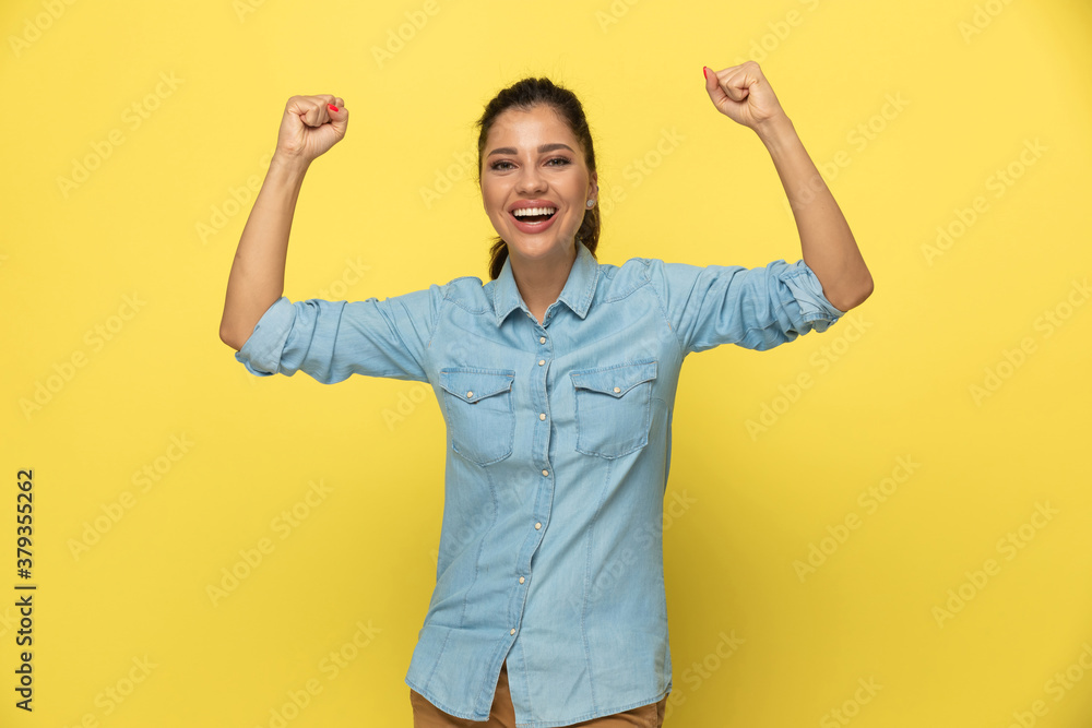 Wall mural Cheerful casual woman laughing and celebrating