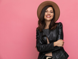 Fototapeta premium Smiling fashion model holding hands folded and wearing hat