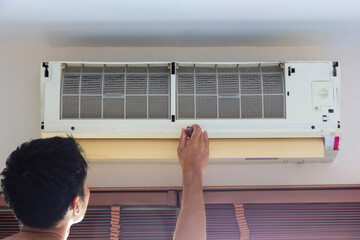 man was remove the air conditioner cover until visible to air filter waiting clear or repair