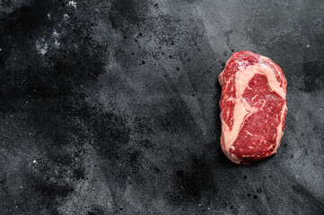 Raw fresh marbled meat Steak Ribeye. Black Angus Rib eye. black background. top view. Copy space