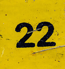 The number 22 is black on a yellow background. Grunge style, scratches and scuffs