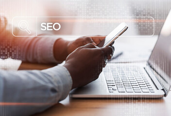 African American Businessman Browsing Internet On Smartphone In Office