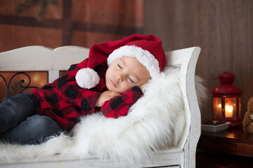 Obraz premium Sweet blonde toddler boy, sleeping with letter to Santa in hand, wishing present for the holidays