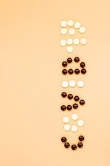 the word covid is made up of white and brown tablets. the view from the top