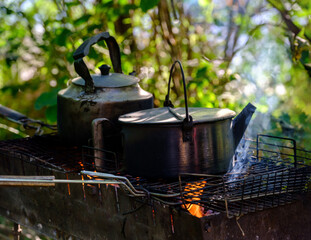 kettle on the fire fire for tea and coffee. Hot and aromatic coffee with kettle on campfire