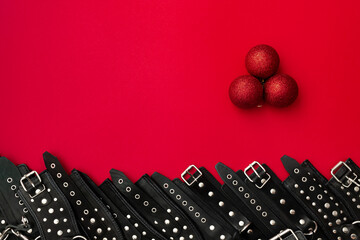 Red banner with three christmas ball and black leather bracers and metal rivets for shackling hands...