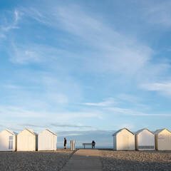 people near beach huts in cayeux s mer in french normandy under blue sky