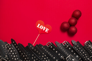 Red banner with penis from christmas balls and black leather bracers and metal rivets for shackling...