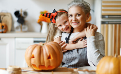 Happy granddaughter and grandmother preparing for Halloween celebration.