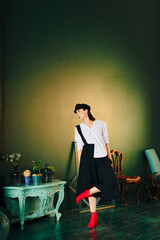 Portrait of a beautiful young woman in a white shirt and black trousers at home