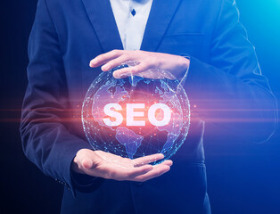 Businessman Holding Holographic World Globe With Word Seo, Blue Background