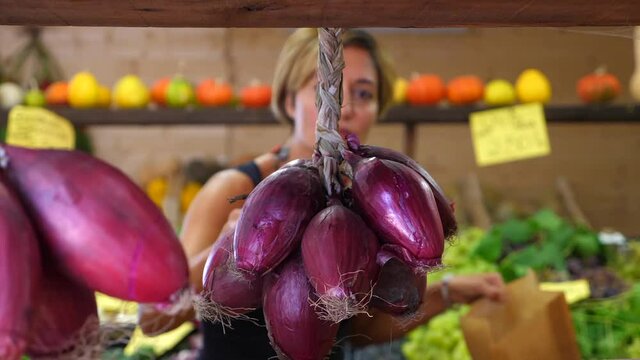 Signora fa la spesa al mercato ortofrutticolo. Italia - Cipolle rosse di Tropea - Lady is shopping at the fruit and vegetable market. Italy - Tropea red onions