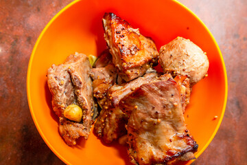 Delicious fried pork ribs served on orange plate