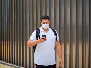 Shot of a walking young man in a medical mask - new normal