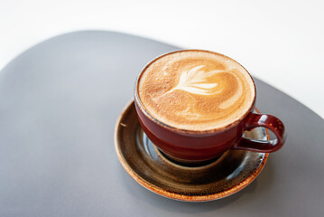 Morning coffee in a ceramic cup with foam on a saucer. Coffee break in a cafe. Aroma fresh...