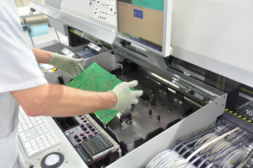 production and assembly of printed circuit boards in an industrial factory - workers check quality