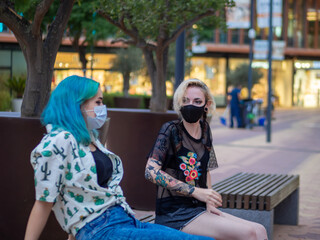 Shot of two women wearing medical masks talking to each other  - new normal