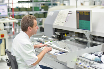 engineering in microelectronics: workers in the production and assembly of electronic high tech components in a modern factory