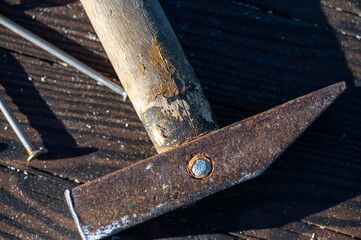 Old vintage hammer and nails on a wooden background, close-up, selective focus.