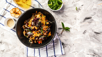 Vegetarian stew eggplants, onions, garlic and paprika, carrot, with herbs on a light background, Vegan food. top view.. Traditional korean food