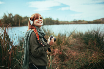 Young woman taking photos in the forest with an old camera