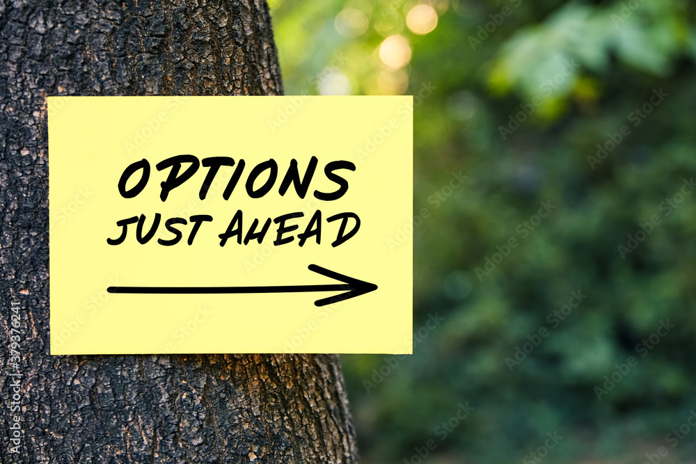 Poster options just ahead motivational message written on paper on a tree in nature. inspirational quote to