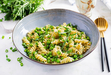 Vegan salad. Fusilli pasta with green peas and onions. Italian food.