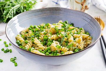 Vegan salad. Fusilli pasta with green peas and onions. Italian food.